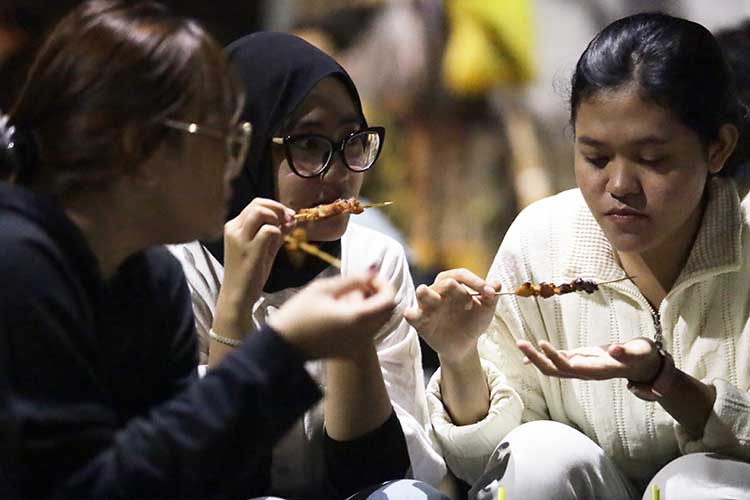 SANTAI: Sejumlah warga menikmati produk sate-satean di salah satu angkringan di Jalan Kaca Piring, Depan Stadion Bayuangga, Kelurahan Sukabumi, Kecamatan Mayangan, Kota Probolinggo.