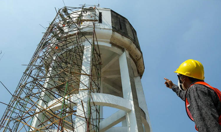TINGGI: Pekerja yang memoles menara air di kawaan Alun-alun Pasuruan. Bangunan cagar budaya ini nantinya juga akan dijadikan museum mini untuk menunjang tourist information centre.