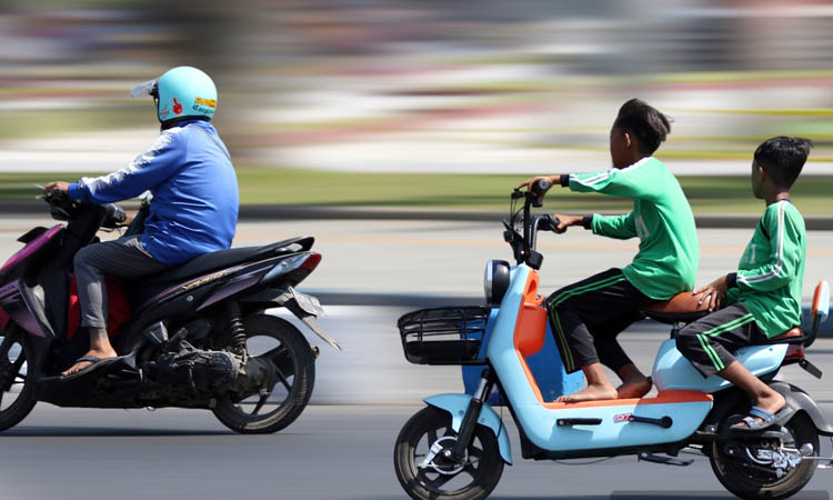 TANPA PENGAMAN: Bocah mengendarai sepeda listrik melintas di sekitar Alun-alun Pasuruan.