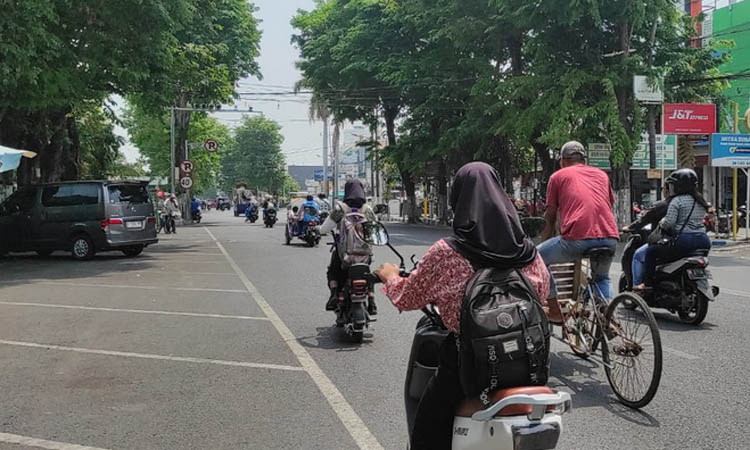 TANPA PENGAMAN: Siswi mengendarai sepeda listrik dan melaju di Jalan Panglima Sudirman.