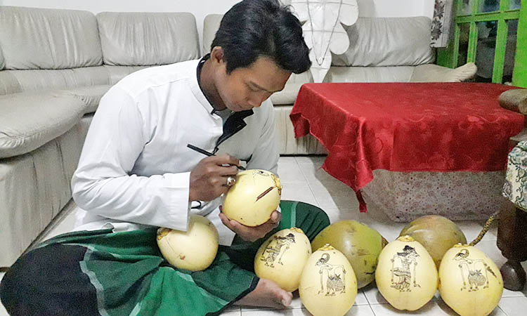 TELATEN: Muhammad Hafidul Kamil kerap mendapatkan pesanan melukis kelapa gading untuk acara mitoni.