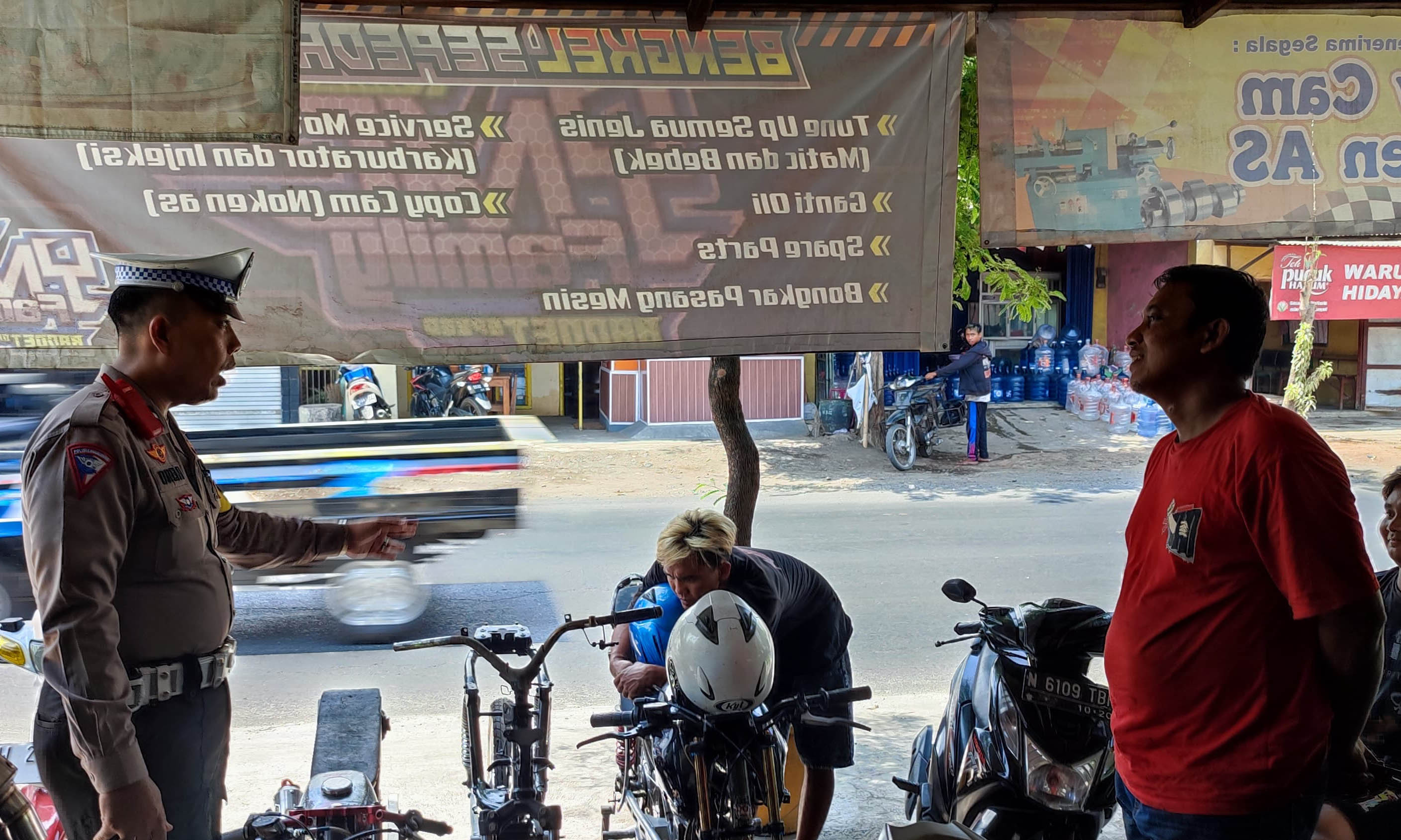 JADI PANTAUAN: Personel Satlantas Polres Pasuruan Kota mendatangi salah satu bengkel sekaligus menyosiaisasikan agar pengelola jangan mau mensetting motor balap.