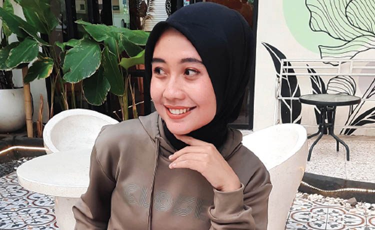 SANTAI: Dita Frety Raka Putri menggunakan hoodie warna hijau