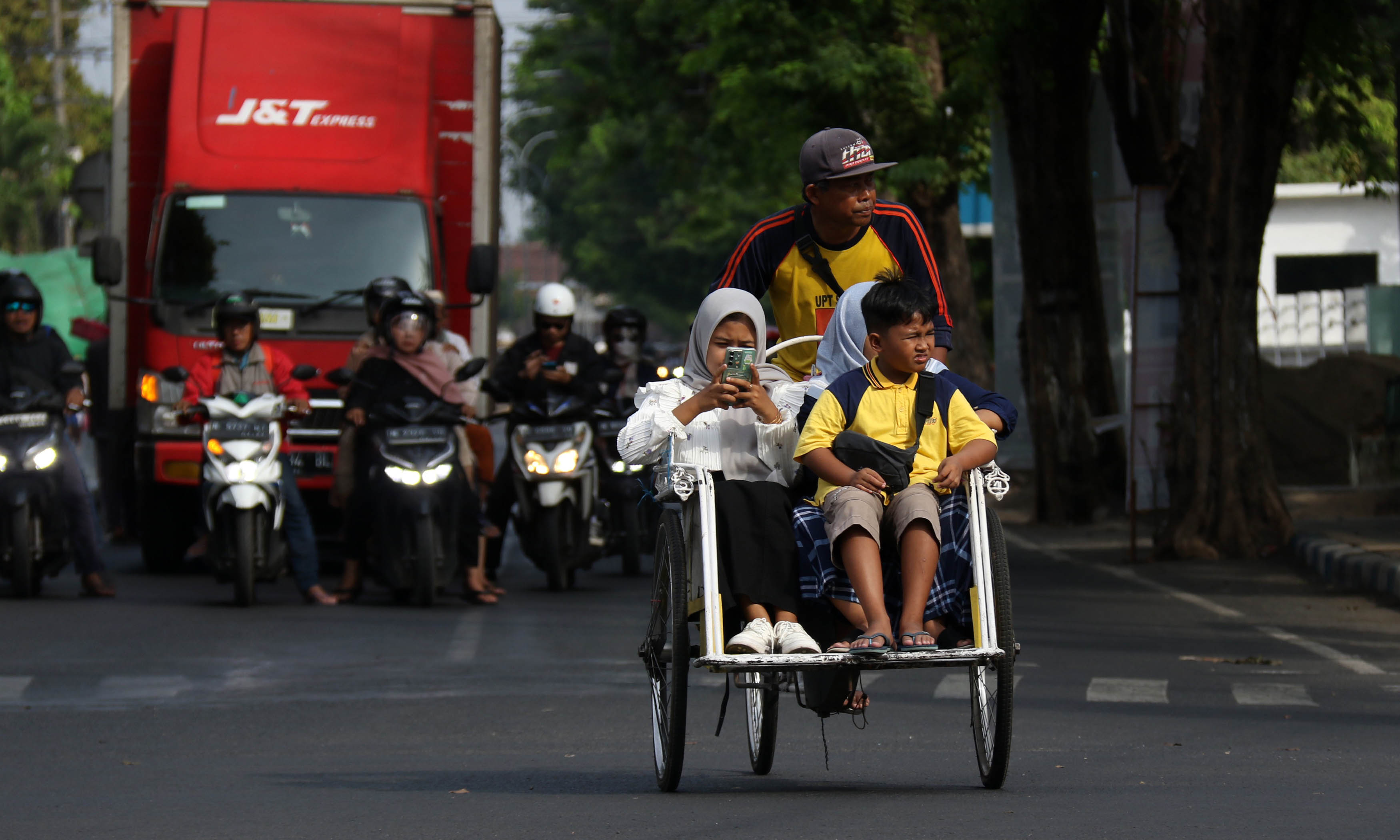 MENGAIS REZEKI: Abang becak membawa penumpang melintas di jalan Kota Pasuruan. Kini, Dishub menyiapkan sanksi bagi becak yang melanggar.