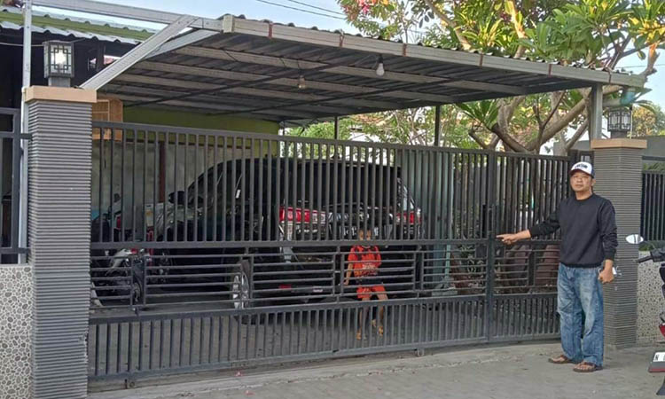 DIRUSAK: Polisi menunjukkan pintu masuk yang sebelumnya digembok dan dirusak pelaku.