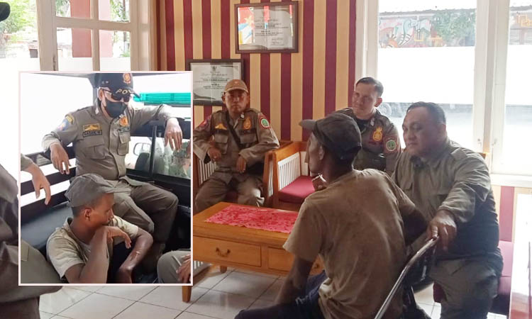 HATI-HATI: Personel Satpol PP membujuk Mul setelah diamankan di jalan.