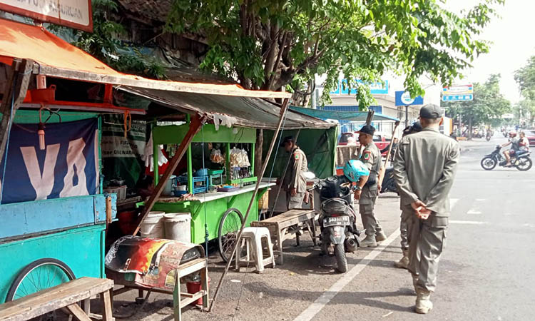 DIWARNING: Personel Satpol PP mendatangi lapak PKL di Kumala, Jumat (24/11).