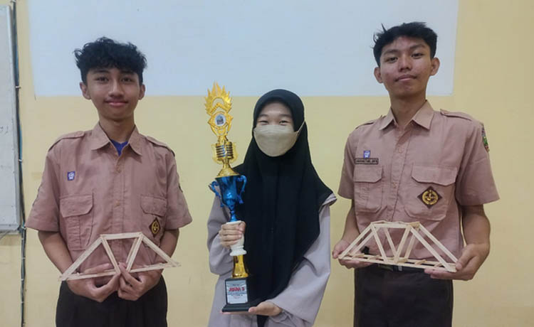 KIRI-KANAN: Ali Baba, Andyana Wijayanti dan Ahmad Bustanul Arifin memamerkan desain jembatan dan trofi juara 3 dari Civil Creative Competition.