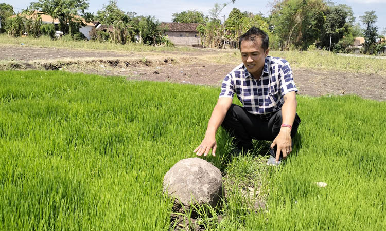 DIKERAMATKAN : Kaur Umum Desa Bulu Mohammad Topan melihat batu persegi delapan di Dusun Sumber.