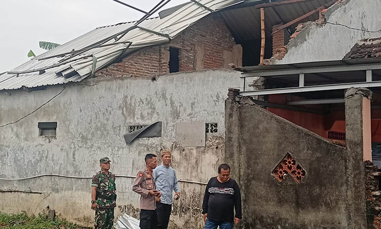 PENDATAAN: Kapolsek Pandaan Kompol Marwan Ishery Purnomo saat meninjau rumah warga yang atapnya mengalami kerusakan usai kena sapu puting beliung, (2/12).