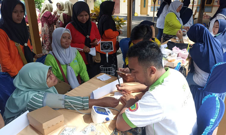 PEMERIKSAAN KESEHATAN: Salah satu warga memeriksakan kesehatannya. Pemeriksaan meliputi cek tensi darah, gula darah, hingga kolesterol.