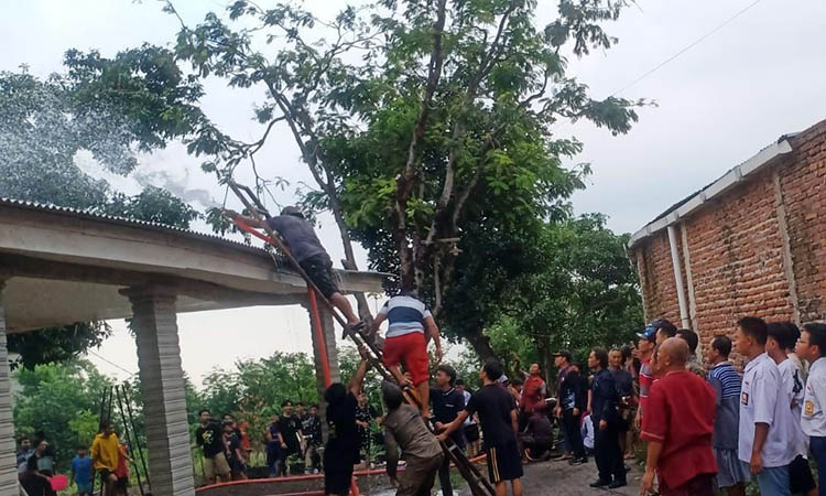 AMUK SI JAGO MERAH: Warga ikut membantu damkar memadamkan api yang melalap rumah Kuswaji, Selasa (5/11).