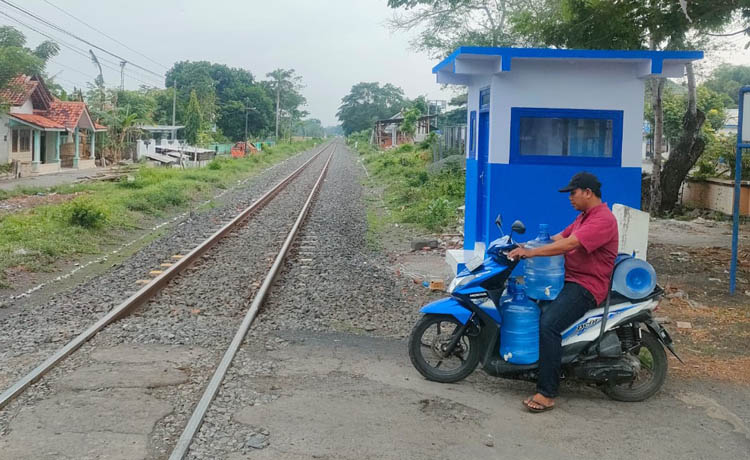 HAMPIR RAMPUNG: Pengendara motor melintas di JPL 178 di Kecamatan Sumberasih, yang tahun ini dibangun pos jaga dan palang pintu perlintasan.