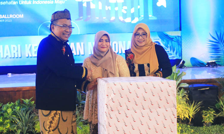 DOOR PRIZE: Plt Kadinkes Kabupaten Probolinggo Mujoko, M.Mkes. dan Ketua Panitia HKN dr. Dewi Vironica, M.Epid. menyerahkan door prize utama.