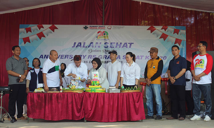 TASYAKURAN: Direktur Utama PT Graha Sehat Lestari Kraksaan Ir. Made Sindrajaya memotong tumpeng disaksikan Direktur RS Graha Sehat dr. Susanti Sugianto, M.ARS. (empat dari kanan) dan undangan.