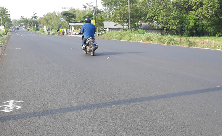 RAMPUNG: Sejumlah pengendara melintas di Jalan Raya Leces, Desa Malasan Kulon, yang sudah rampung dilebarkan.
