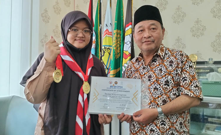 BANGGA: Hasna Widyaningrum (kiri) didampingi Kepala SMAN 1 Pandaan Ariadi Nur Awalukianto (kanan), menunjukkan medali dan sertifikat diraihnya juara kompetisi AOMC 2023 di Filipina