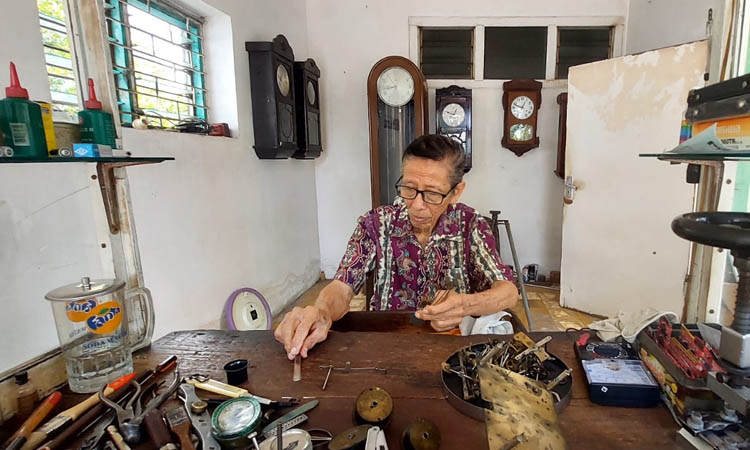 LANJUTKAN USAHA AYAH: Kristanto di meja kerja ruangannya membenahi jam milik pelanggan.