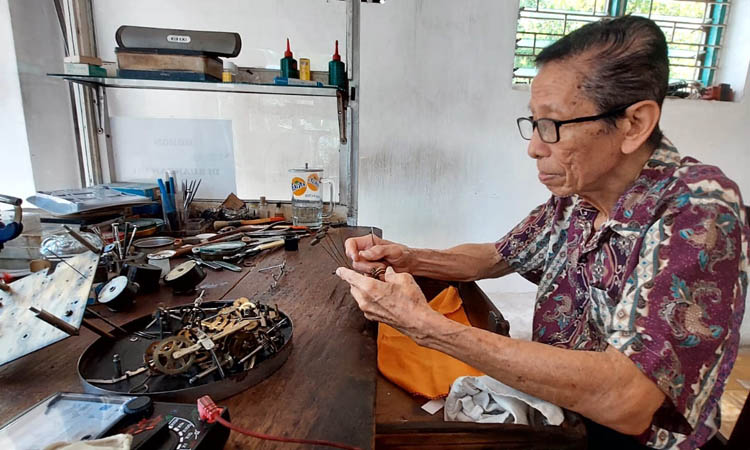 LANJUTKAN USAHA AYAH: Kristanto di meja kerja ruangannya membenahi jam milik pelanggan.