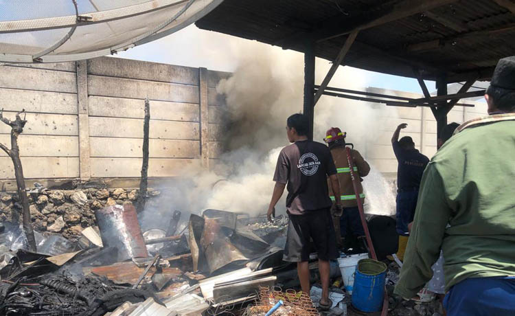 PROSES PEMADAMAN: Petugas damkar dan sejumlah warga saat membantu memadamkan api di gudang besi milik Saramdi Curah Sawo, Kecamatan Gending,&nbsp; kemarin.