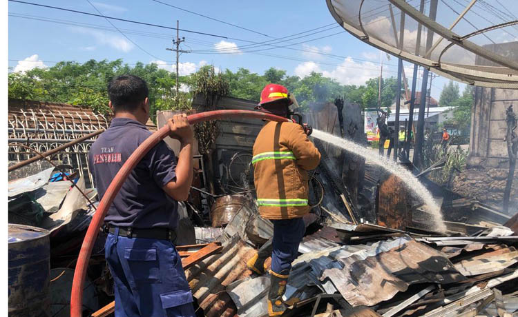 PROSES PEMADAMAN: Petugas damkar dan sejumlah warga saat membantu memadamkan api di gudang besi milik Saramdi Curah Sawo, Kecamatan Gending,&nbsp; kemarin.