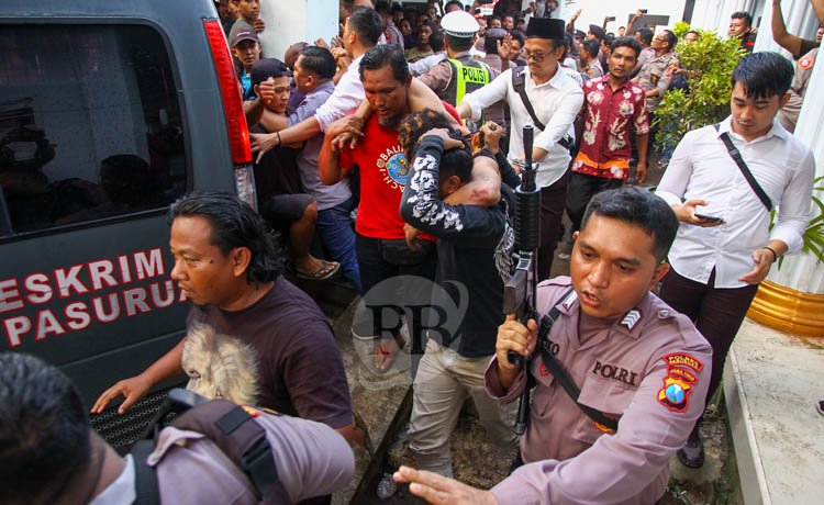 EKSTRA: Petugas mmbawa senjata saat mengamankan Yas.