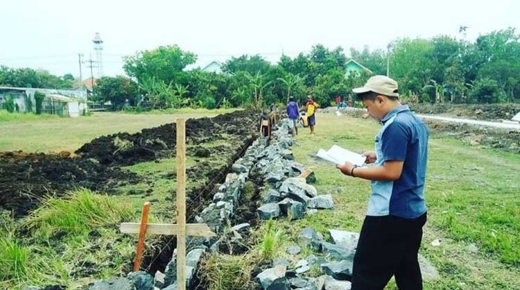 PANTAU LANGSUNG: Husni Mubarok memantau langsung proses pembangunan dan menyesuaikan dengan gambar yang dibuatnya. (Husni Mubarok For Jawa Pos Radar Bromo)
