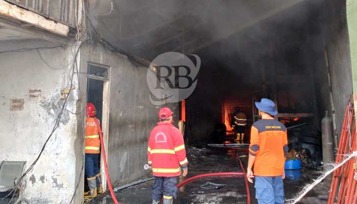 AMUK SI JAGO MERAH: Petugas damkar saat berupaya memadamkan api di gudang springbed Desa Pucangsari, Purwosari. (Rizal Syatori/ Radar Bromo)