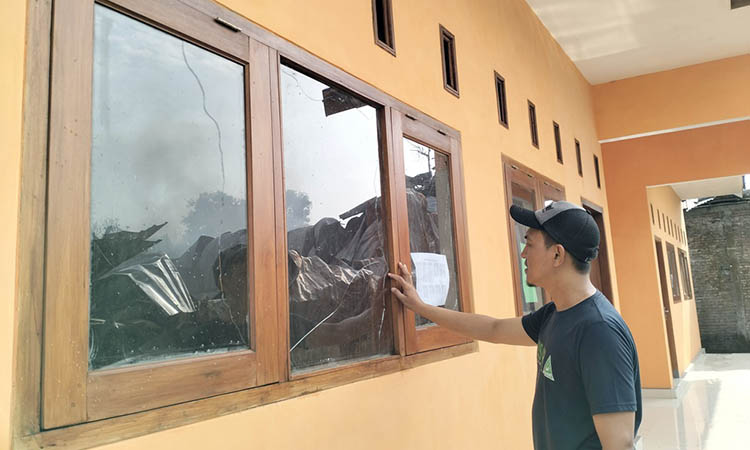 RETAK: Dua kaca jendela Madrasah Quran Al-Ikhlas retak karena panas yang ditimbulkan dari api yang membakar pabrik spring bed, Senin (8/1).