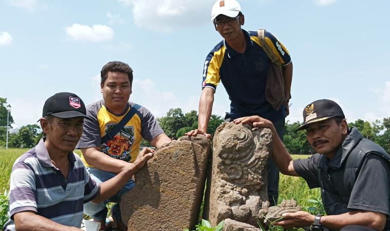 TUNJUKKAN: Sejumlah perangkat Desa Ketompen, Kecamatan Pajarakan, memperlihatkan batu yang memiliki ukiran di lokasi situs Ketompen. Batu tersebut dipercaya merupakan sisa dari candi yang menjadi pert