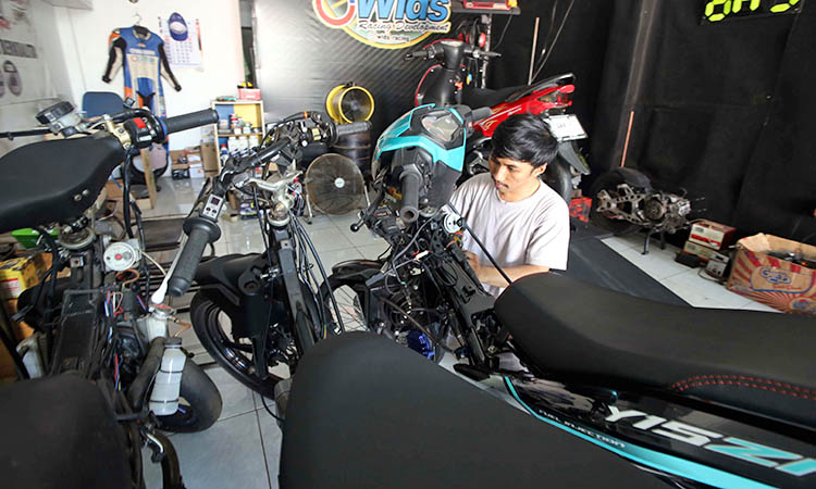 PASANG DATA LOGGER: Denny Ahmad, memasang data logger pada motor di bengkel milik Ghani Widiyanto.
