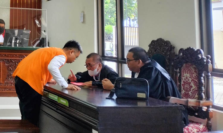 KONSULTASI: Terdakwa Andrie Wibowo Eka Wardhana berdialog dengan penasihat hukumnya dalam sidang.