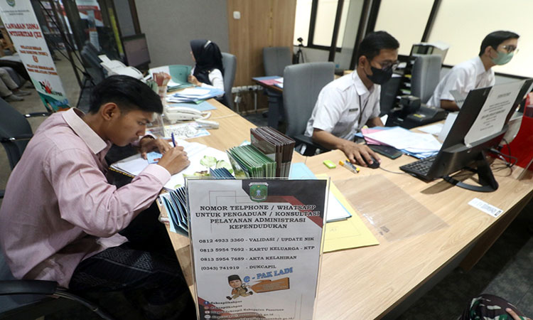 LAYANI: Salah satu warga saat mengajukan permohonan layanan di Dispendukcapil Kabupaten Pasuruan.