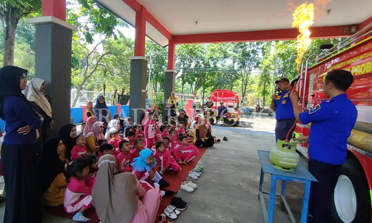 BELAJAR: Personel Damkar Kabupaten Probolinggo mendemonstrasikan cara memadamkan api kepada siswa