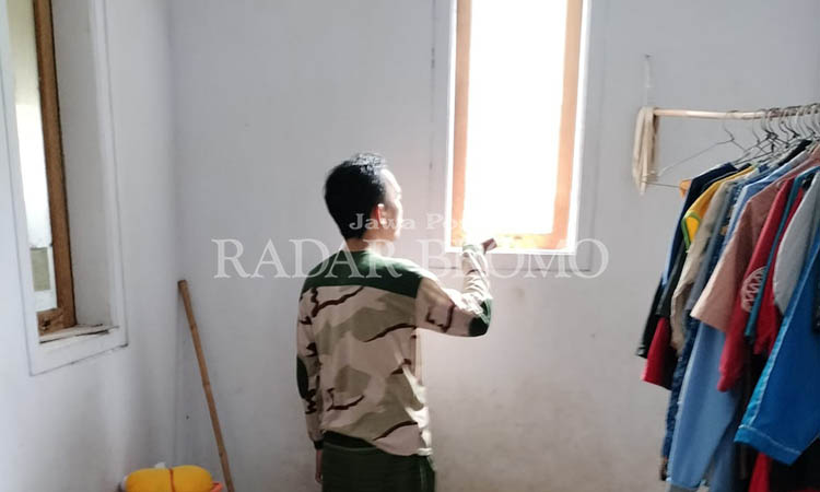 LEWAT JENDELA: Korban Syamsul Arifin, 45, memperlihatkan jendela garasi yang diduga jadi tempat maling motor masuk.