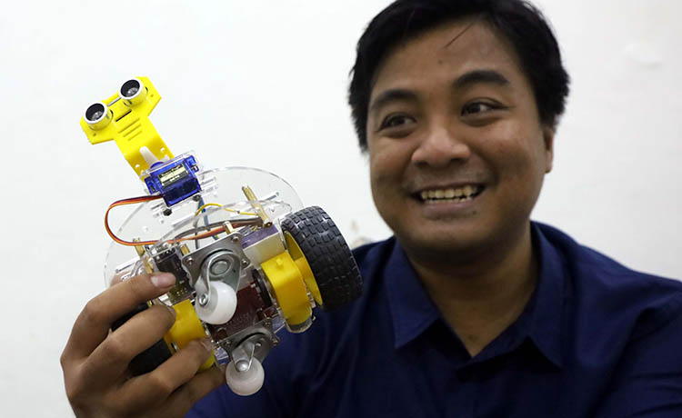 TUTOR ROBOTIK: Gamma Kristian Adikurnia, menunjukkan salah satu karya anak didiknya.