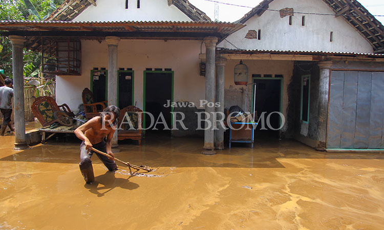 BERSIH-BERSIH: Warga di Dusun Jetis, Desa Prodo, Kecamatan Winongan, Kabupaten Pasuruan membersihkan lumpur di rumah masing-masing setelah banjir bandang yang mener