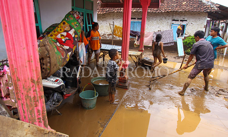 BERSIH-BERSIH: Warga di Dusun Jetis, Desa Prodo, Kecamatan Winongan, Kabupaten Pasuruan membersihkan lumpur di rumah masing-masing setelah banjir bandang yang mener