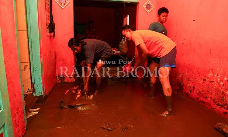 BERSIH-BERSIH: Warga di Dusun Jetis, Desa Prodo, Kecamatan Winongan, Kabupaten Pasuruan membersihkan lumpur di rumah masing-masing setelah banjir bandang yang mener