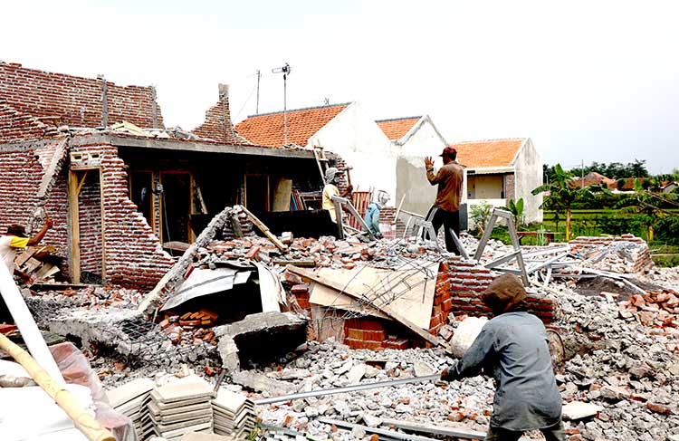 AMBRUK: Sejumlah tukang bangunan membersihkan sisa puing material bangunan rumah Hasan yang ambruk di Jalan Pakis, Lingkungan Makmur, Kelurahan Triwung Kidul.