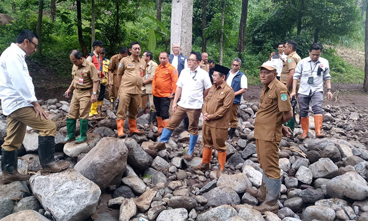 PANTAU: Pj Bupati, Andriyanto dan beberapa pegawai Pemkab Pasuruan saat meninjau lokasi terjadinya banjir bandang di Lumbang.