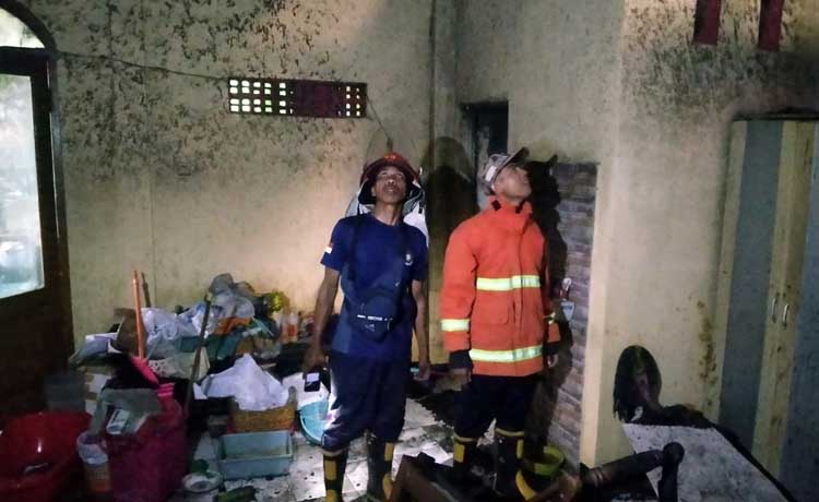Tim damkar saat berupaya memadamkan api di rumah Asnawi.