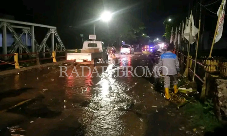 MELUAP: Air dari sungai Petung meluap hingga ke jembatan Buk Wedi di Kelurahan Blandongan, Kecamatan Bugul Kidul, Kota Pasuruan, Selasa (6/2).
