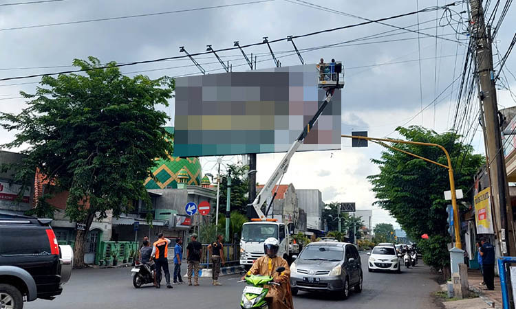 DICOPOT: Sejumlah petugas mencopot APK salah satu caleg yang terpasang di Jalan Panglima Sudirman, Kota Probolinggo.