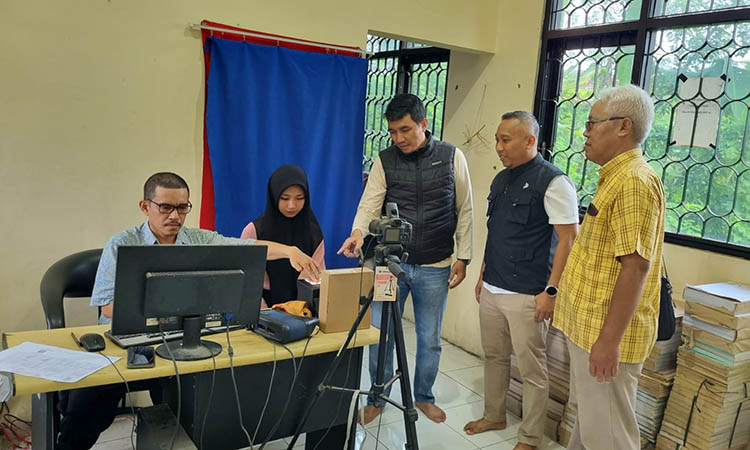 LAYANI: Kepala Dinas Kependudukan dan Catatan Sipil Kabupaten Pasuruan, Tectona Jati saat memantau proses perekaman data e-KTP warga.