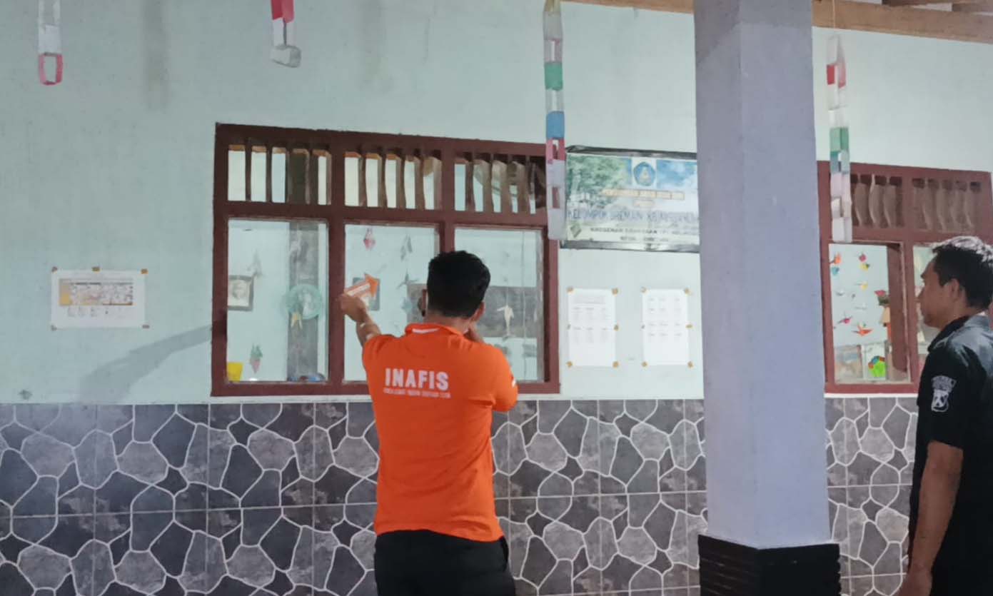 DIRUSAK: Polisi melakukan identifikasi di rumah SN yang kacanya dirusak oleh massa.