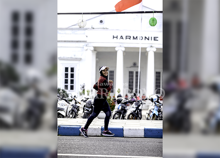 BERLARI: Anggun lari di Jalan Pahlawan, Kelurahan Pekuncen, Panggungrejo. Ia melintas di depan Gedung Harmoni, Kota Pasuruan.