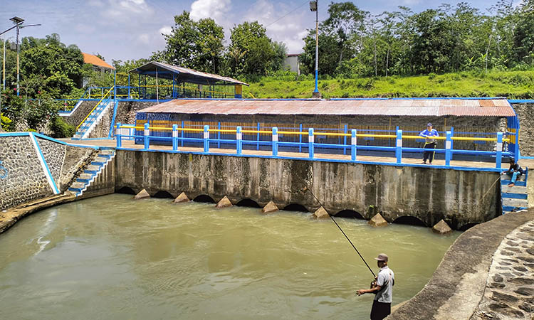 KOKOH: Penjaga Pintu Air Dam Delapan Ahmad Shiddiq berdiri mengecek aliran air Dam Delapan.