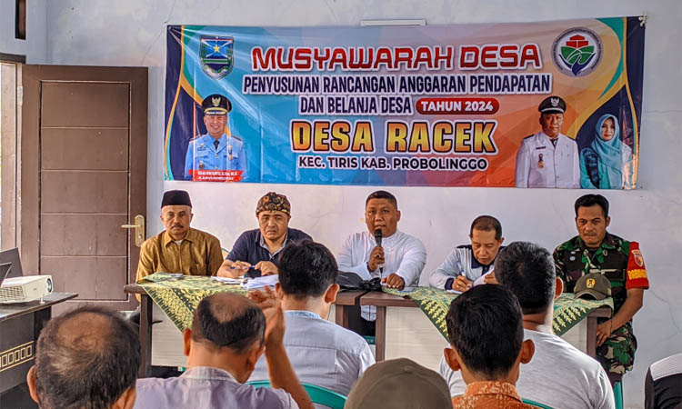 SINERGI: Kepala Desa Racek Hosnadi, S.H. (pegang mik), dalam musyawarah di Kantor Desa Racek.&nbsp;