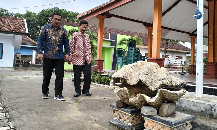 RIWAYAT: Fosil kerang yang berada di depan Balai Desa Sumberkerang, Kecamatan Gending.